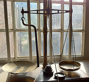 Old fashion balance scales in front of a Victorian window