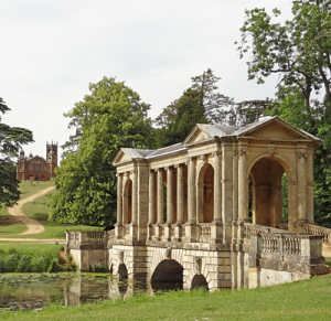 Palladian Bridge, Stowe Park, England: Classical stone bridge over ornamental lake. Path leading to rusticated folly in the background.